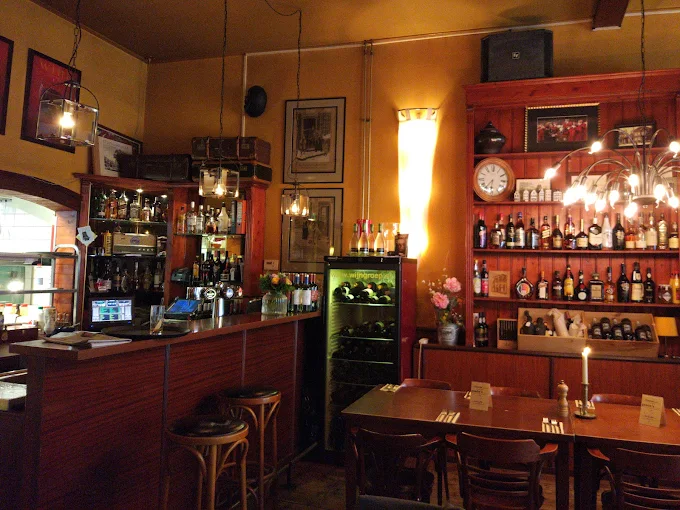De bar van De Ouwe Compagnie met de houten wandkast vol flessen